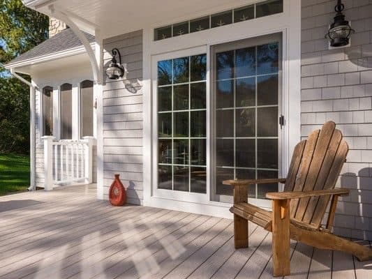 New patio door with transom windows opening onto a porch